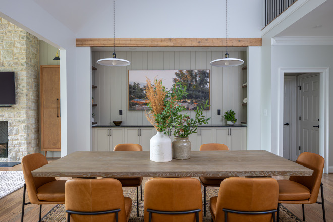 dining-room-double-pendant-lighting Dining room featuring two pendant lights above a wood dining table, warm leather dining chairs, custom built-ins, and Sherwin Williams Reserved White walls.