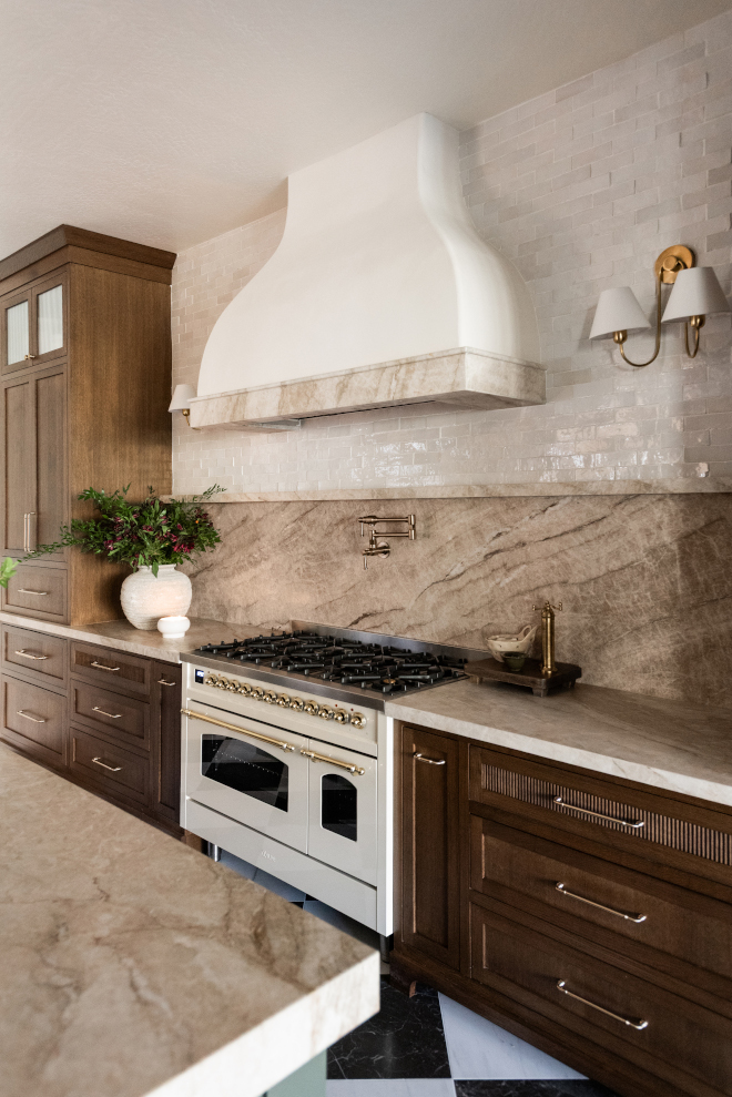 brass-kitchen-sconces-custom-range-hood Brass wall sconces with white shades flanking a custom plaster range hood above a luxury kitchen range.