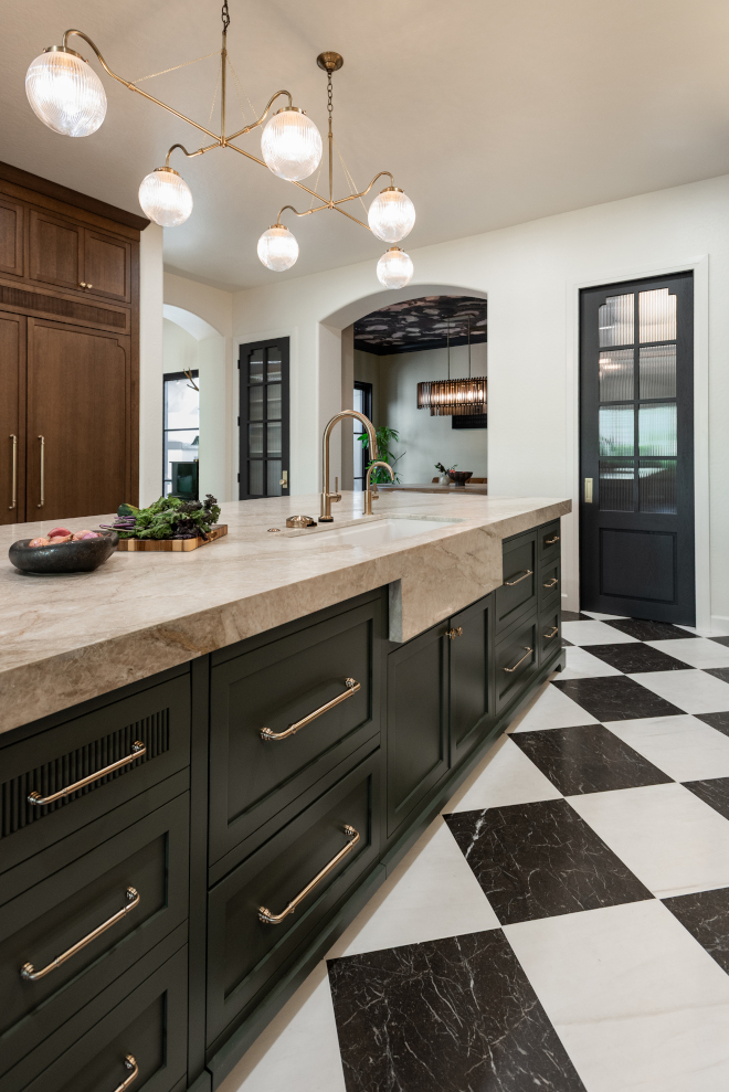 taj-mahal-quartzite-apron-front-sink Apron-front sink wrapped in Taj Mahal Quartzite with a brass faucet on a dark green kitchen island.