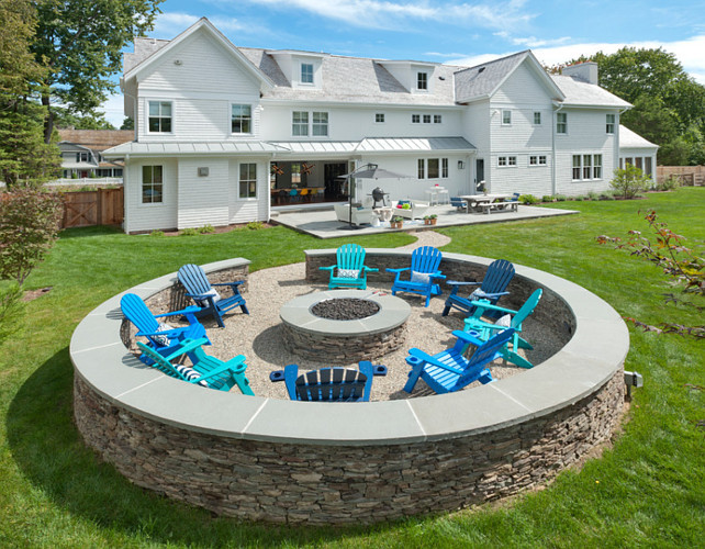 Fire pit design. Backyard with fire pit. Backyard with bluestone patio and winding natural stone path leading to a fire pit surrounded by a circular fieldstone sitting wall. #Firepit #Backyard Blue Water Home Builders.