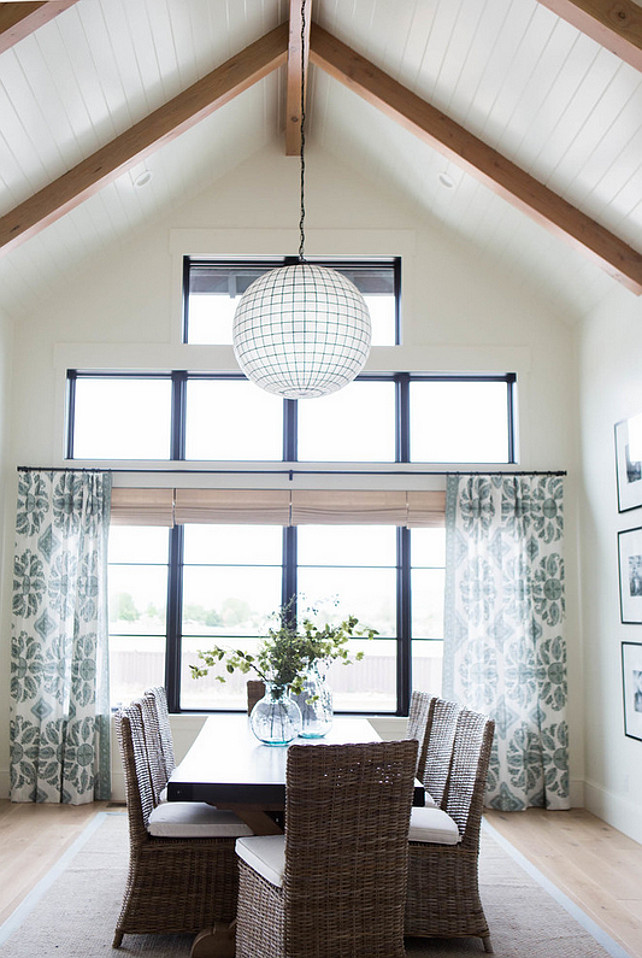 Dining Room. Restoration Hardware Capiz Shell Pendant. Beautiful dining room features a Restoration Hardware Capiz Shell Pendant illuminating a rectangular black dining table lined with wicker dining chairs. #DiningRoom #RestorationHardwareCapizShellPendant