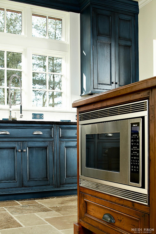 Kitchen Renovation. Kitchen Renovation Ideas. Interior Designer Kitchen Renovation Tips. The kitchen remodel started from the floor up. To give the kitchen an inviting farmhouse feel, pummeled limestone cut in irregularly sized tiles were selected. To create contrast with the light, rough-hewn stone, cherrywood painted in a deep blue finished, glazed and crackled, and distressed cherry on the island were chosen to convey a timeworn charm. #Kitchen #KitchenRenovation #KitchenReno #KitchenRemodel Heidi Piron Design.