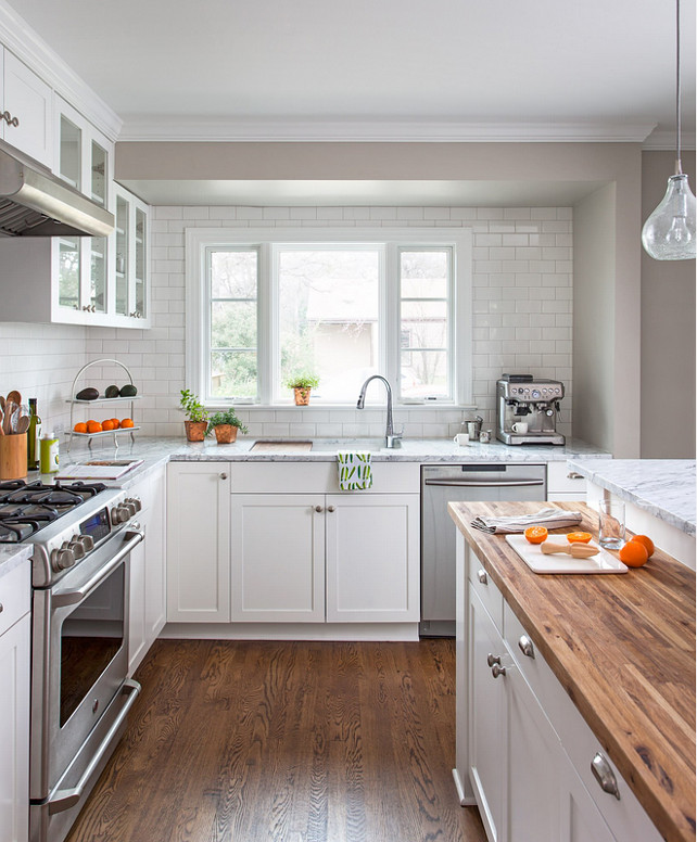 Small Kitchen Design Ideas. This small family home kitchen features 3cm Bianco Carrara Marble counters, hardware salvaged from original kitchen, a mixture of new and old oak flooring, Rittenhouse 3x6 white gloss tile for the backsplash, Benjamin Moore Simply White paint on the ceiling, BM Revere Pewter on the walls, and a clear Shades of Light Teardrop Seeded Pendant above the island. #SmallKitchen #Kitchen.jpg