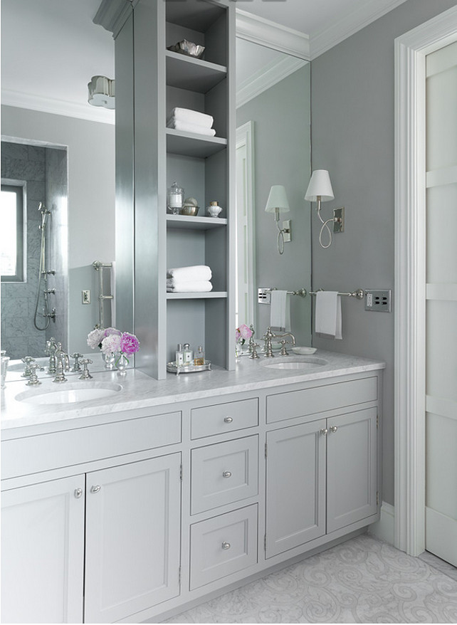 Gray Bathroom. Grey master bathroom features gray shaker washstands topped with white marble fitted with his and her sinks under full height frameless mirrors flanking a grey shelving unit alongside a mosaic marble floor. Jenny Wolf Interiors.