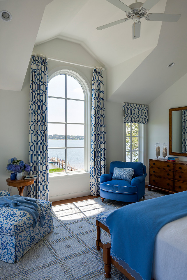 Blue and white Master Bedroom. Blue and white coastal bedroom. Blue and white master bedroom design. Blue and white master bedroom with ocean views. This bedroom offers stunning water views and floor-to-ceiling windows. In fact, notice how the draperies were installed in this space. Blue and white master bedroom with pale gray wall paint color. #Blueandwhite #masterbedroom SLC Interiors.