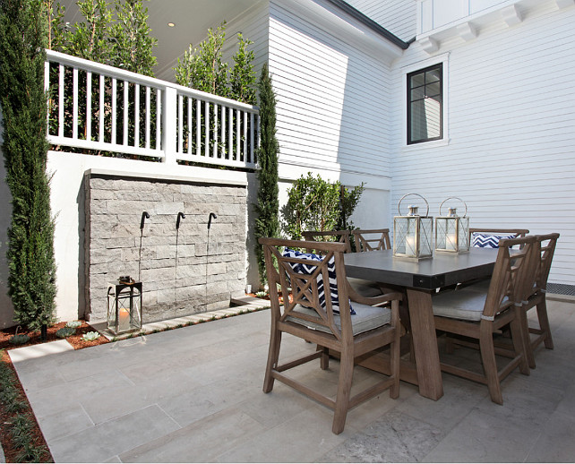 Backyard Patio with zinc top table, teak chairs, natural stone flooring and water feature. #Patio Spinnaker Development.