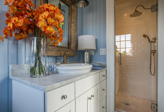 Bathroom Shower Ideas. Crisp white hues displayed in the vanity cabinetry and above the sink transition through the glass shower door into classic subway tiles.