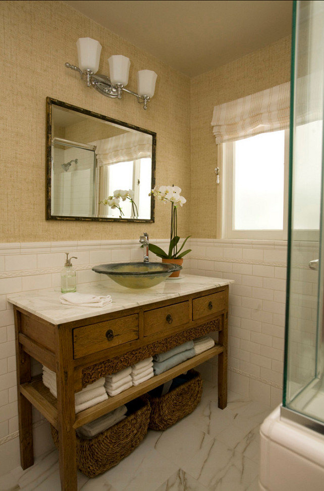 Bathroom. A casually elegant guest bathroom featuring a vanity made from a Chinese cabinet, topped with Calacutta marble and an ocean inspired vessel sink. Vinyl grasscloth wallcovering lend a relaxed feeling. The floor features