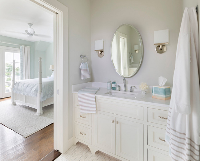 Bathroom. White and soft gray bathroom. Bathroom with off-white cabinet, white countertop and soft gray walls. This color scheme looks great with the flooring. #barhroom Digs Design Company.