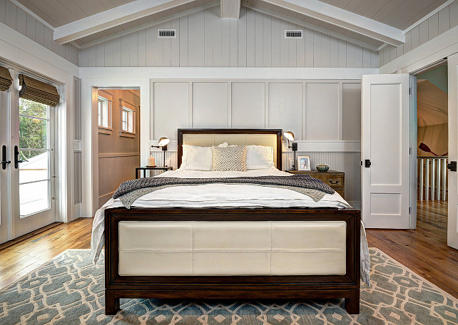 Bedroom. Blue and white area rug, cathedral ceiling bedroom, dark wood bed frame, French doors, glass doors, gray wall paneling, master bedroom, pitched ceiling, white beams. #Bedroom