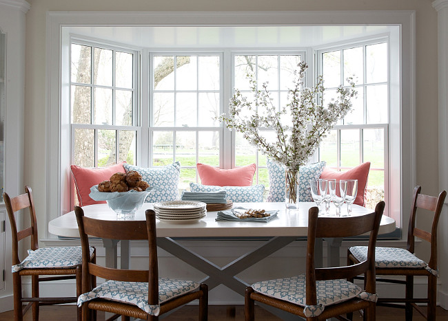 Breakfast Nook. Breakfast nook accented with coral and blue pillows paired with x base dining table surrounded by vintage ladder back chairs flanked by builtin hutches. #BreakfastNook Kerry Hanson Design.