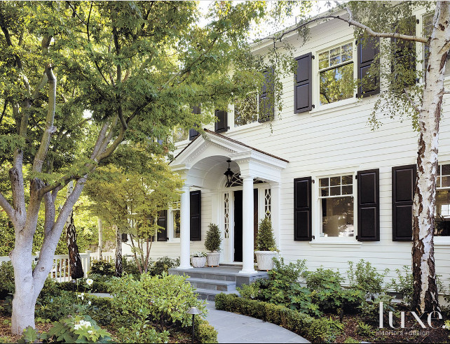 Classic Dutch colonial-style home is complete with a Connecticut bluestone entry porch that invites guests in. Greenery compliments the space and the home’s classic, white façade. Matthew Millman Photography.