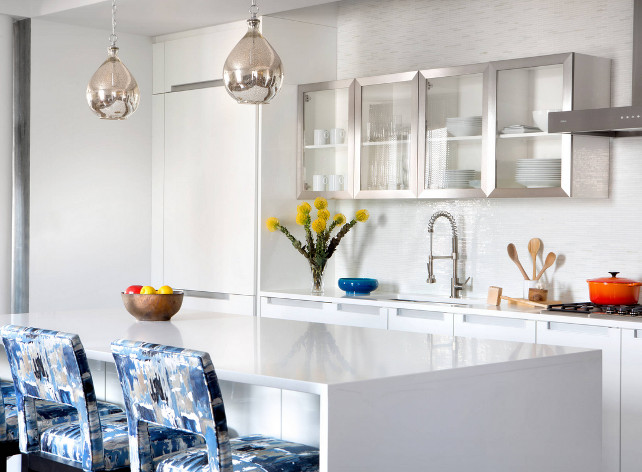 Contemporary white kitchen. Contemporary white kitchen with abstract ikat fabric stools (This fabric is from Beacon Hill. The collection is called Annina Indigo and the colorway is simply blue.), industrial faucet, pewter cabinets, silver pendant lighting. #kitchen #Contemporary #WhiteKitchen #ikat #ikatfabric #kitchenstools CRD Associates.