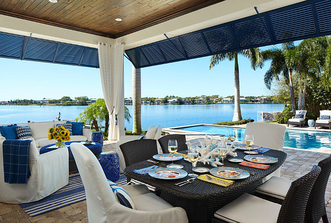 Covered patio by pool with ocean view. Gorgeous views can be enjoyed from this waterfront lanai. JMA Interior Design.