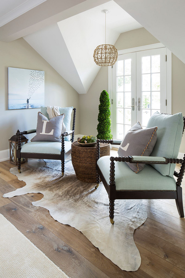 Currey and Co Bayshore Chandelier. Upstairs hallway painted in Benjamin Moore Revere Pewter, cowhide rug, spindle chairs and Currey and Co Bayshore Chandelier.