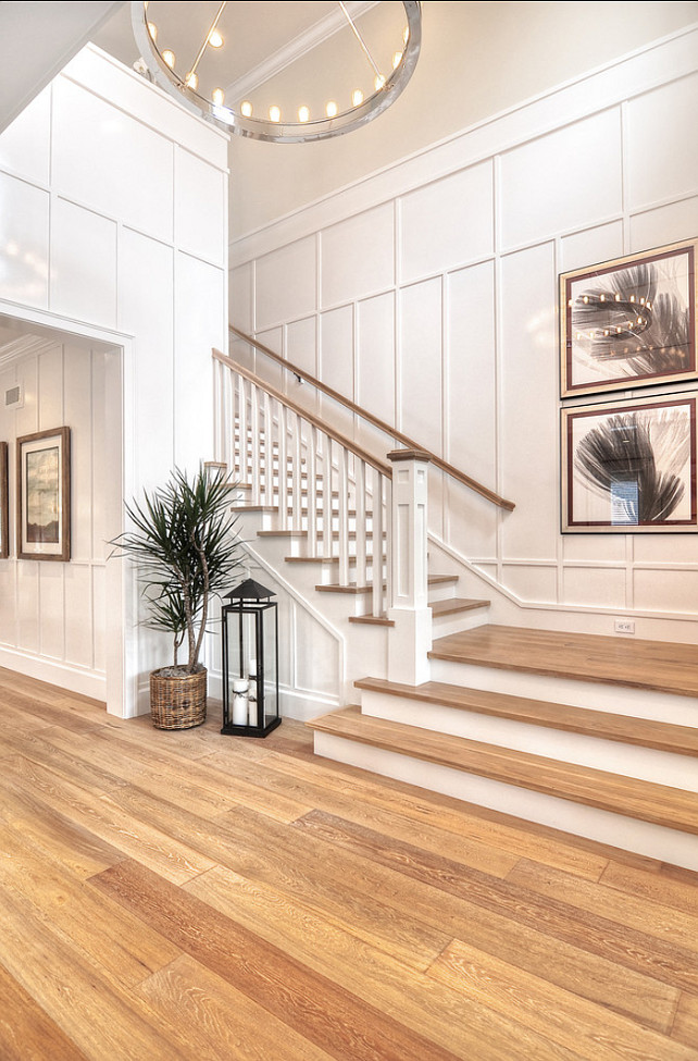 Entryway Ideas. Entryway Design. Transitional Entryway. Detailed finish carpentry consists of wainscoting along the walls as well as floor boards and crown molding in this entryway. Chandelier is the "Roark 40" Modular Ring Chandelier". #Entryway #EntrywayIdeas #EntrywayDecor #wainscoting 