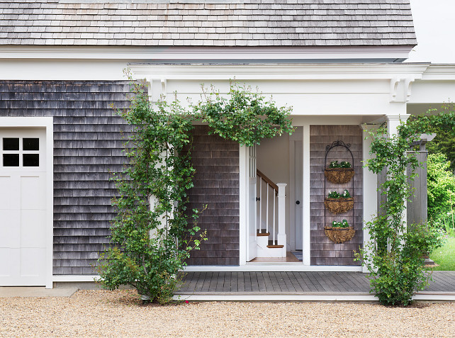 Garden. Beach House Garden. Cottage Garden. Climbing plants. Flower baskets. Gravel driveway. Wall mounted baskets. Weathered wood. Shingle siding. White columns. White door. White fascia