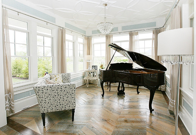 Herringbone pattern hardwood floors. Music room with Herringbone pattern hardwood floors, black grand piano, Robert Abbey Bling Chandelier and mirrored cabinet. Wallpaper is "Thibaut Bentley in Seamist". #Herringbonehardwoodfloors