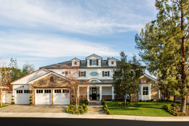 Home Exterior. Home Exterior black shutters covered porch eyebrow dormer window front yard gable dormer window gable roof landscaping stone siding three car garage white square columns