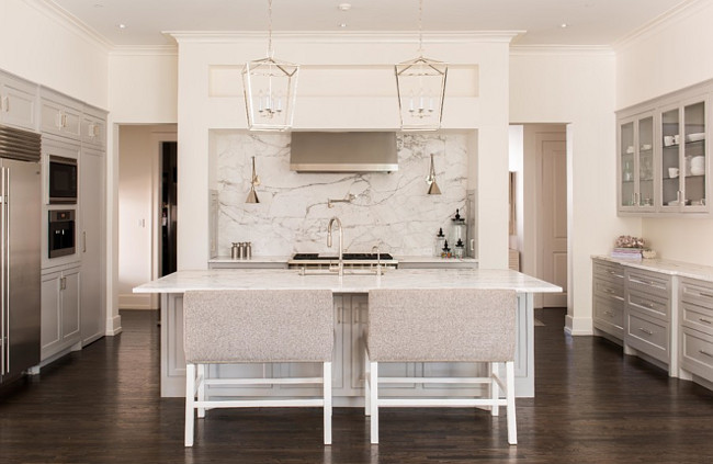 Kitchen Island Bench Barstools. These gray kitchen island bench stools are from Quatrine. Off-white walls play beautifully against pale gray cabinets in this kitchen. The kitchen island measures 5'-0"x 10'-0" Lighting is Darlana Lanterns from Circa Lighting. Countertop and slab backsplash are polished marble. Kitchen faucet is by Kohler. #Barstools #Bench #Kitchen #Kitchenisland L. Lumpkins Architect, Inc.