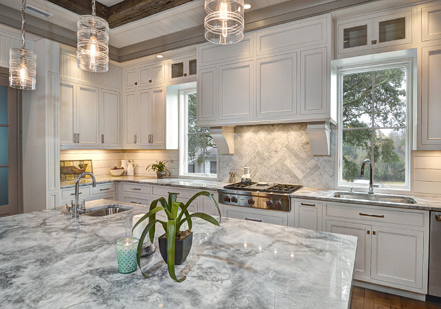 Kitchen. corbels, Darker Trim, double stack cabinetry, gas range, glass cabinets, herringbone, inset cabinets, marble backsplash, pendant lights, prep sink, shiplap, stainless sink, white cabinetry, white countertop, wood backsplash, wood hood. The kitchen lights are the Ella Small Column Pendant, from Juliska. Ink Architecture.