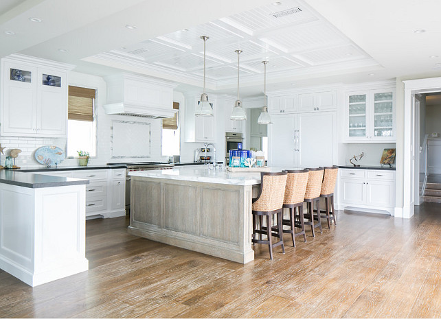 Kitchen. White kitchen with gray countertop, pendant lights, recessed lighting, white cabinets, white kitchen, white marble countertop, white tiles, wood bar chairs, wood floor. #kitchen