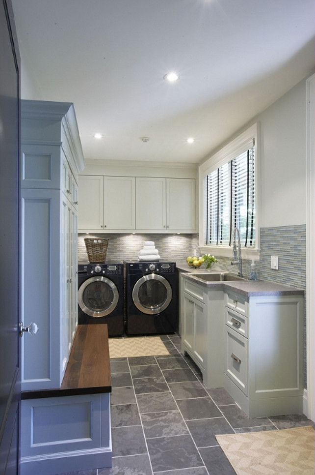 Laundry Room Mudroom. Laundry room and mudroom. Laundry room mud room design with soft gray cabinets, black washer & dryer gray glass tiles backsplash, gray corian counter tops and gray slate floors. Meredith Heron Design 