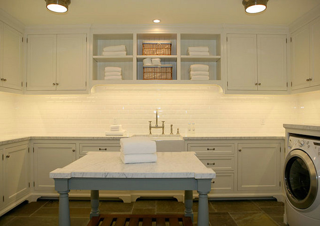 Laundry Room. Second Floor Laundry. Chic large 2nd floor laundry room design with white cabinets, gray laundry room island, calcutta gold counter tops, beveled subway tiles backsplash, farmhouse sink, and white washer & dryer. #LaundryRoom #LaundryRoomDesign Giannetti Home.