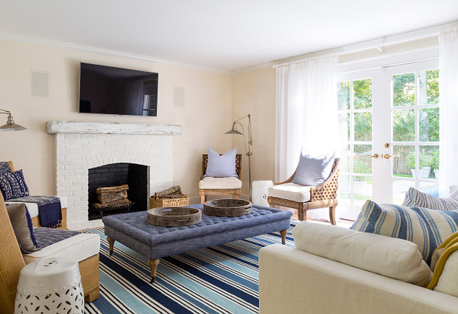 Living Room. Coastal Living room. Living Room. Slipcovered white linen sofa, wood and rattan chairs, linen tufted ottoman. Limed fireplace with custom made reclaimed beam mantel. #LivingRoom Chango & Co.