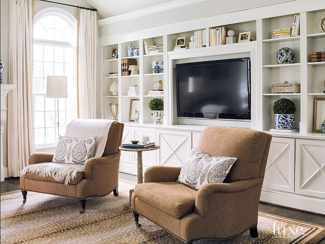 Living room bookcase wall. Lillian August club chairs and a cocktail table by Bliss Studio sit in front of a custom bookcase wall. #Bookcase #wall #Livingroom Beth Gularson. Helen Norman Photography.