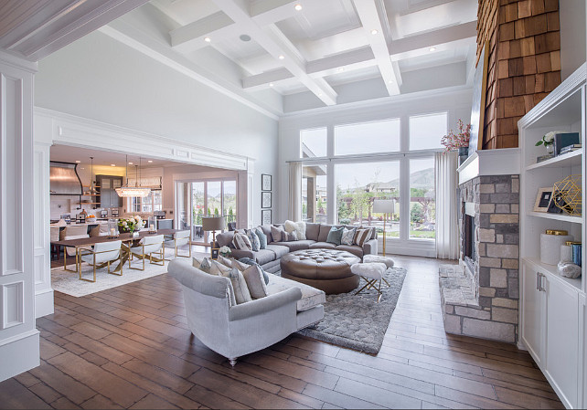 Living room. Living room with shingle fireplace, floor to ceiling windows, plank floors and cross beamed ceiling. #Livingroom Joe Carrick Design.