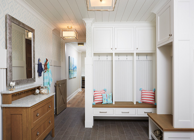 Mudroom. Mudroom with dark gray porcelain tiles, individual cubbies with drawers, cabinet and hooks. A dresser adds extra storage space to this mudroom. Blend Interior Design.