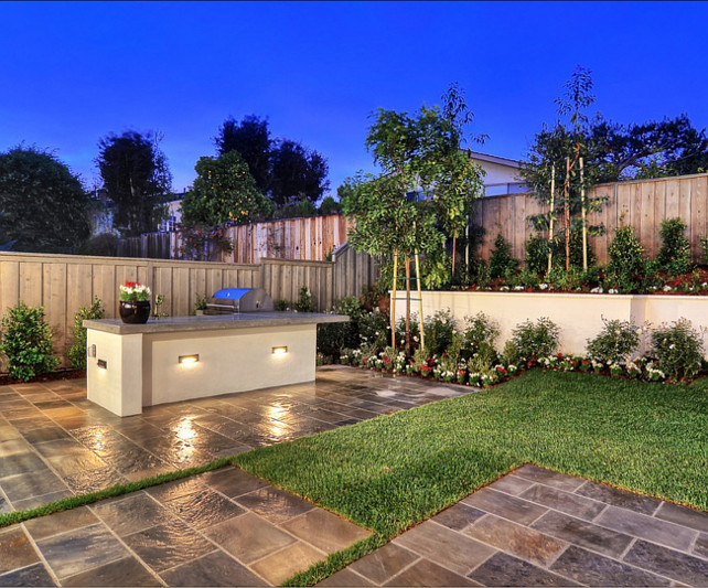 Outdoor Kitchen Ideas. A custom built in kitchen area, including a barbeque and bar, make entertaining a cinch. #OutdoorKitchen #BBQ