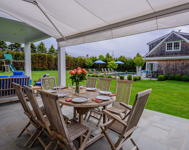 Patio. Covered patio with dining area. Patio dining area with bluestone tile flooring and outdoor teak dining set. #Patio Via Sotheby's Homes.