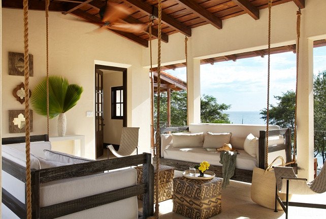 Porch Swing. Two porch swings facing each other in this porch with ocean view. Interior Design by Beth Webb Interiors.