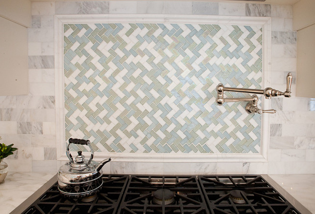 Range Backsplash Ideas. This Oceanside iridescent tile in a herringbone pattern sets off the marble nicely above the range. #RangeBacksplash Kitchen Design Concepts