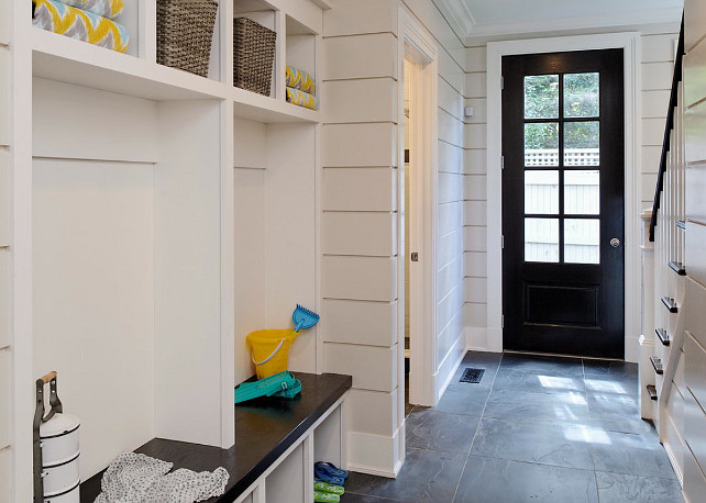 Shiplap Mudroom. Mudroom with shiplap walls, slate flooring tiles, black door and buit-in cabinet with separate cubbies. Slate Floors Mudroom. #Mudroom Blue Water Home Builders.