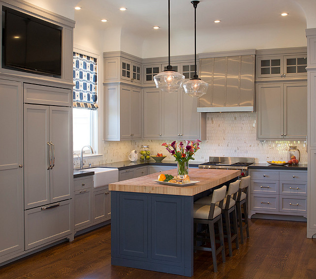 TV Kitchen Ideas. TV Kitchen Cabinet Ideas. TV Kitchen Niche. A niche filled with flatscreen hangs over a gray paneled refrigerator. #Kitchen #TVKitchen #TVNiche Artistic Designs for Living.