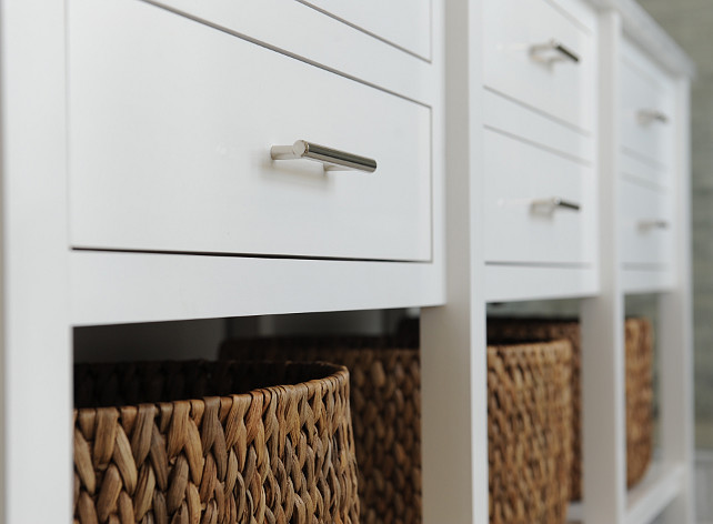 White bathroom vanity. White bathroom vanity featuring an extra long, white dual sink vanity with lower shelf filled with baskets. #WhiteBathroomVanity