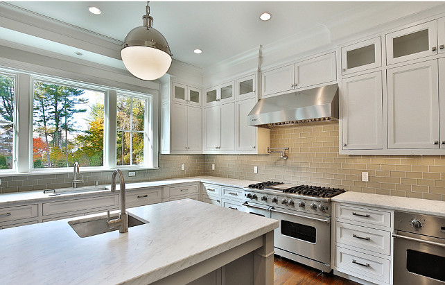 White kitchen with gray subway tile backsplash and honed white marble countertop. White and Gray Kitchen. Blue Water Home Builders.